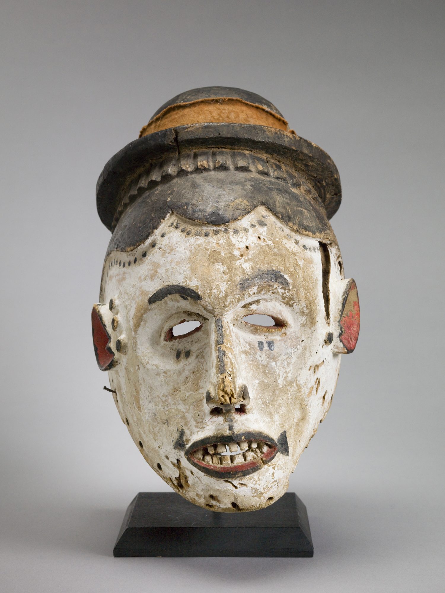 Igbo People, Helmet Mask, 20th Century, wood, pigment, and cloth. Gift of Robert and Suzanne Bach.